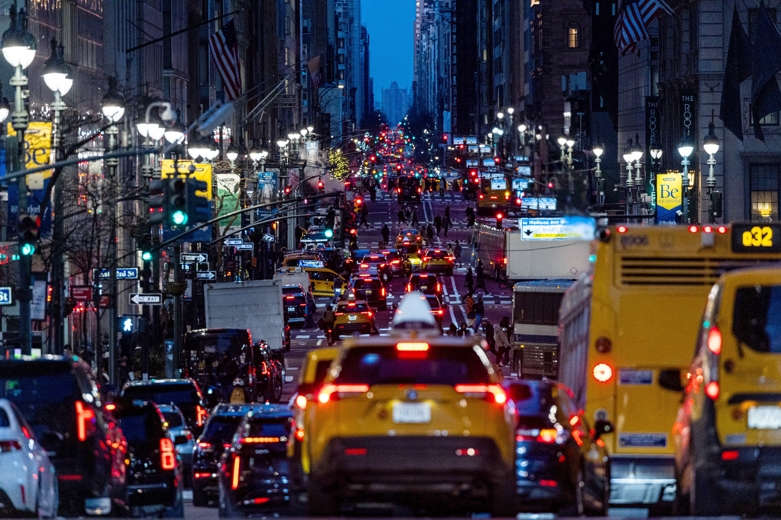 Heavy traffic moves in one direction on a large street at night.