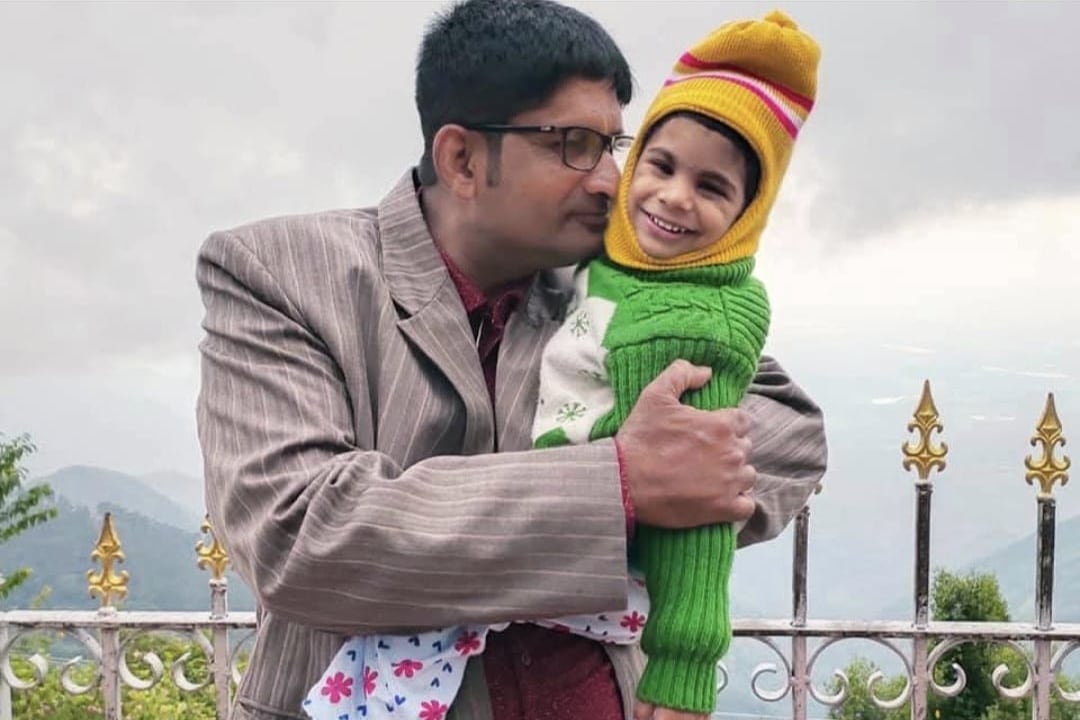 A father holds his 3-year-old daughter.
