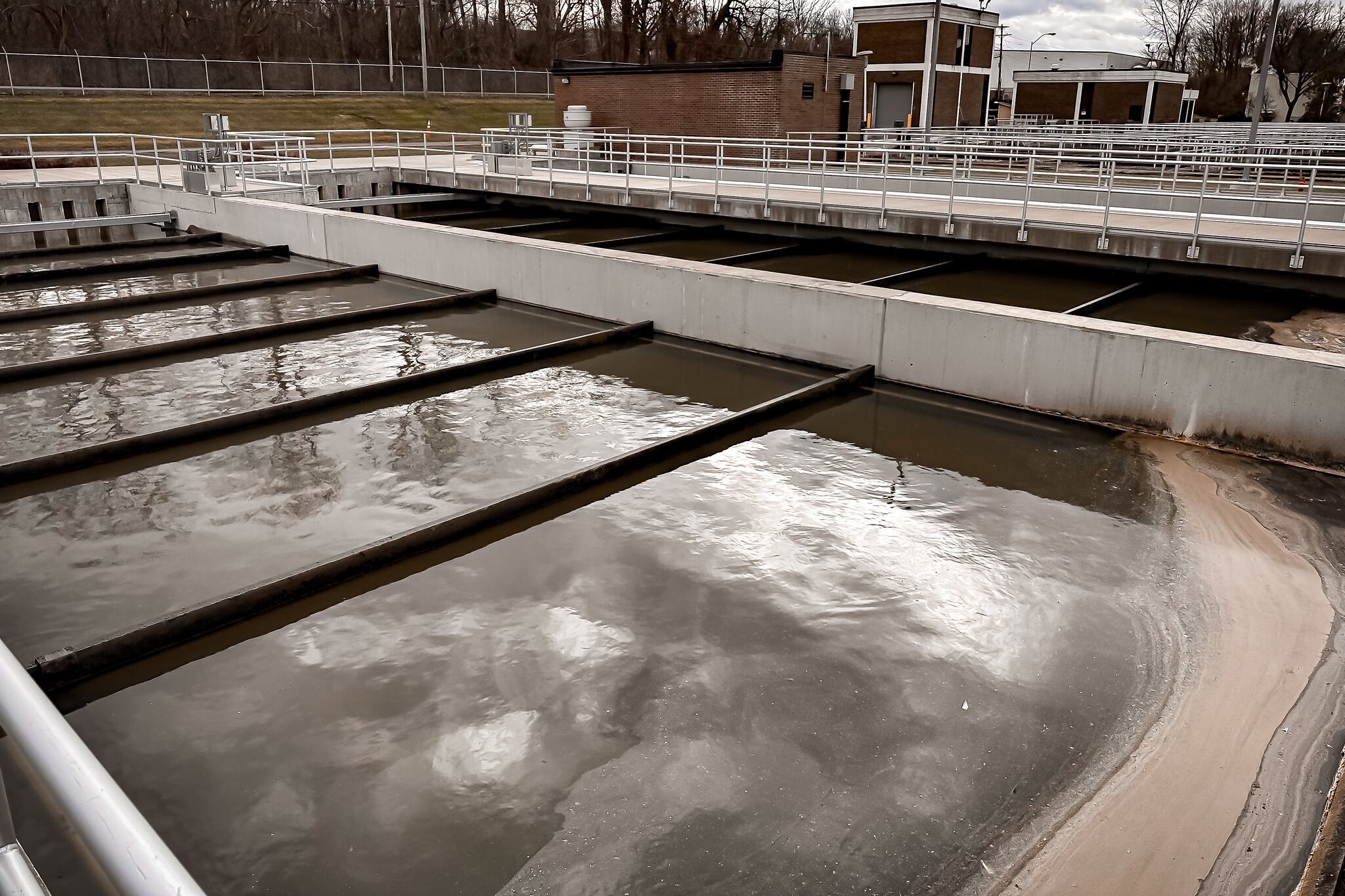 A water pollution control plant where workers collect samples for analysis.