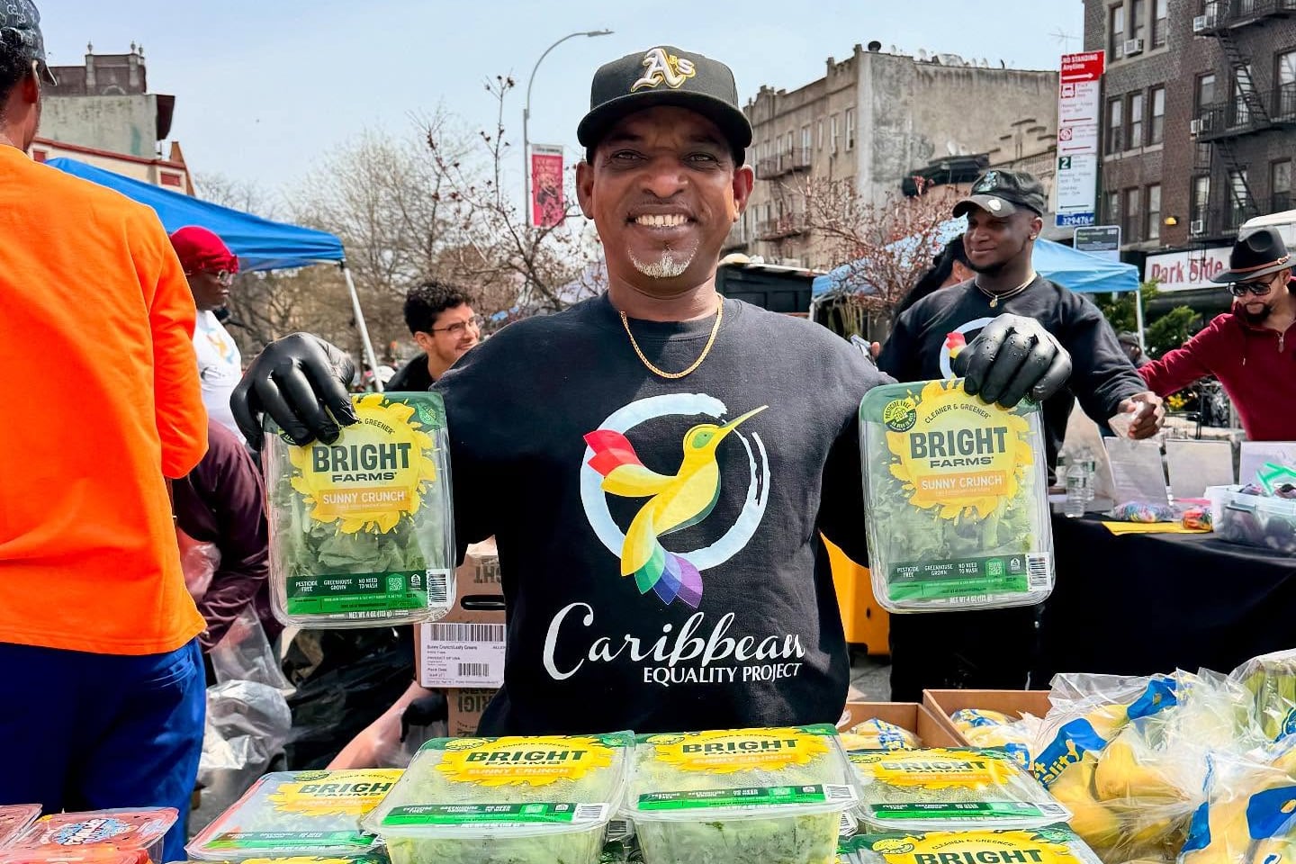 Sean Marcu holds up two packages of lettuce.
