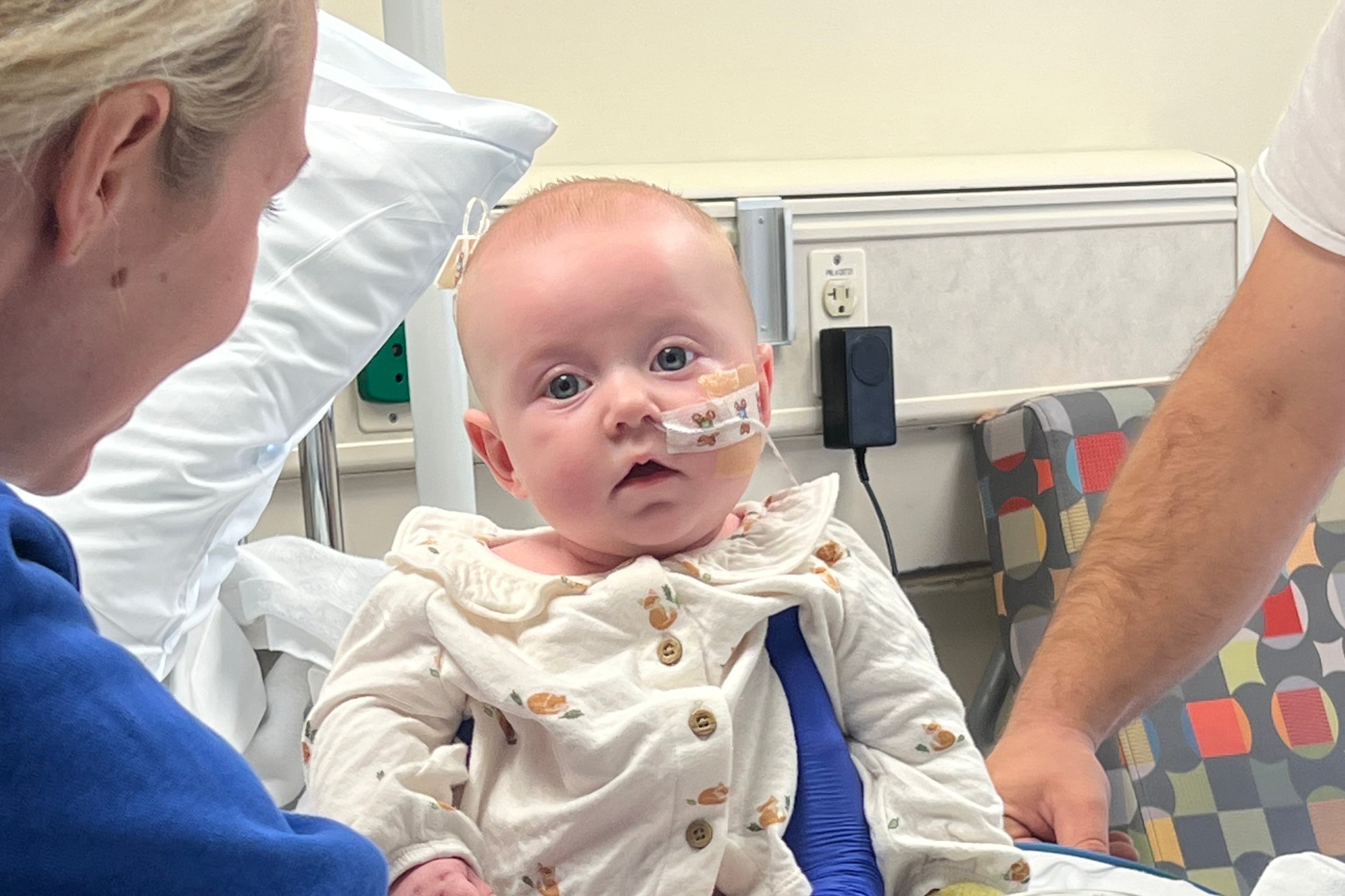 Baby Piper Everett is held up in a hospital bed.