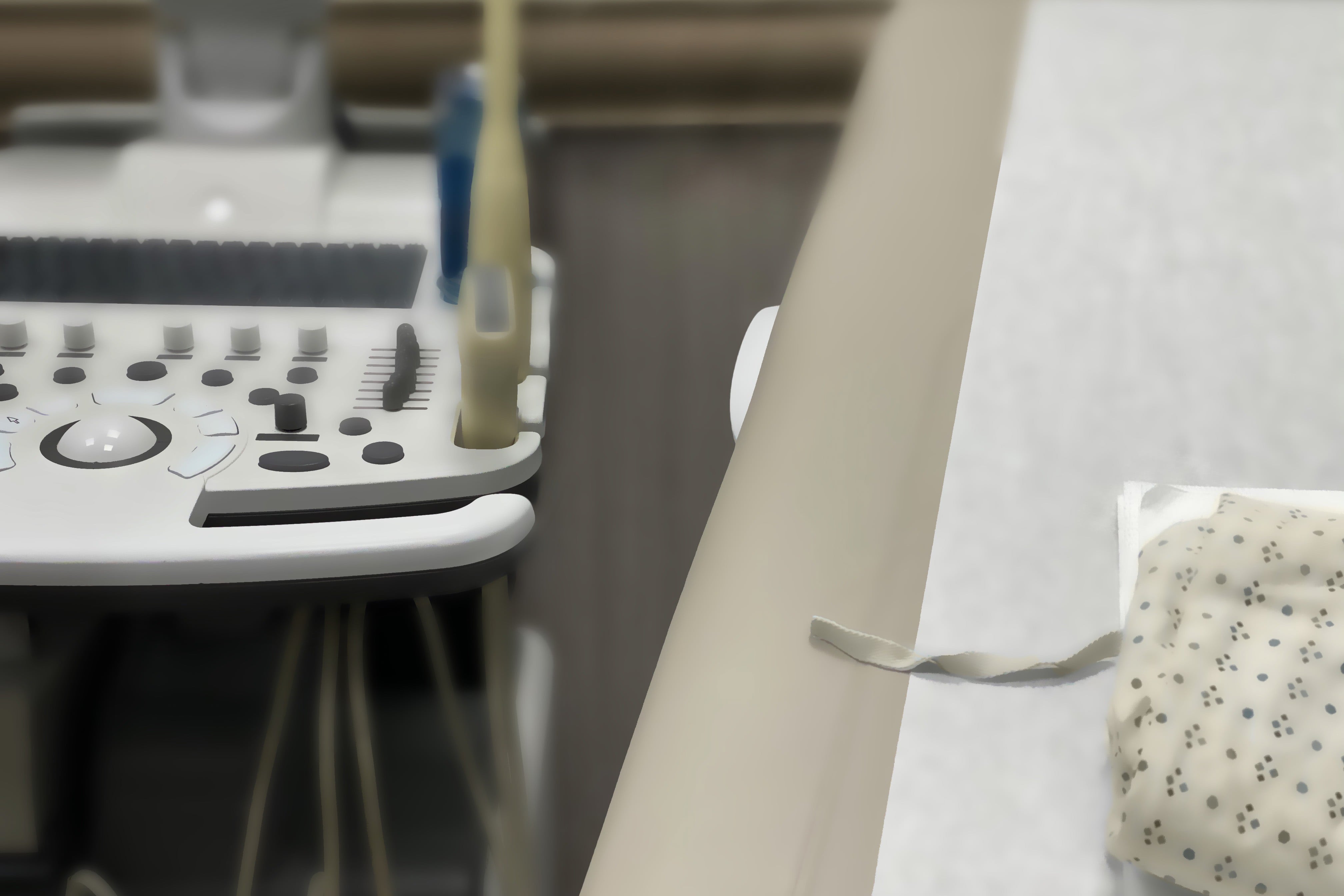 Medical examination table, ultrasound machine & patient gown.