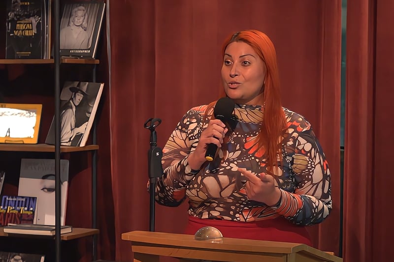 Asha Lyons speaks at a podium.