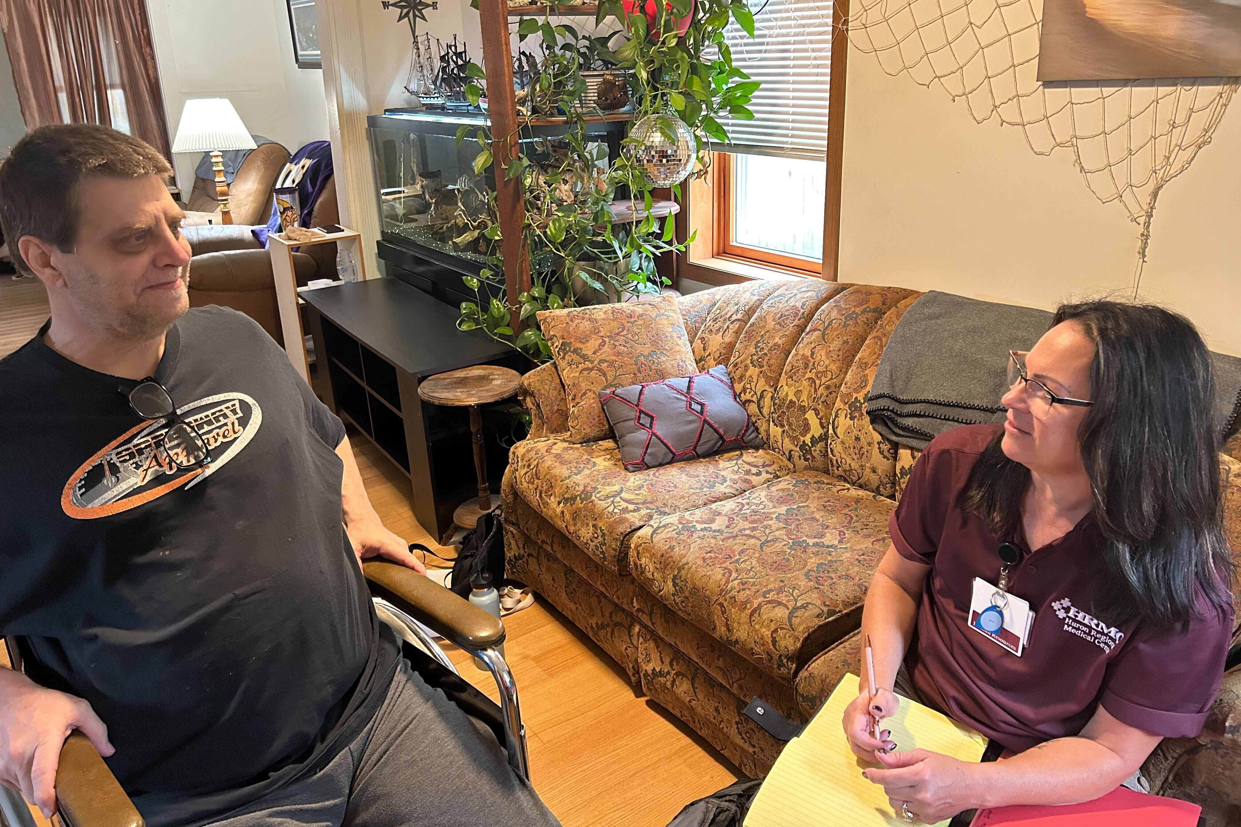 Kelly Engebretson (left) meets with community health worker Mickie Scheibe at his home.