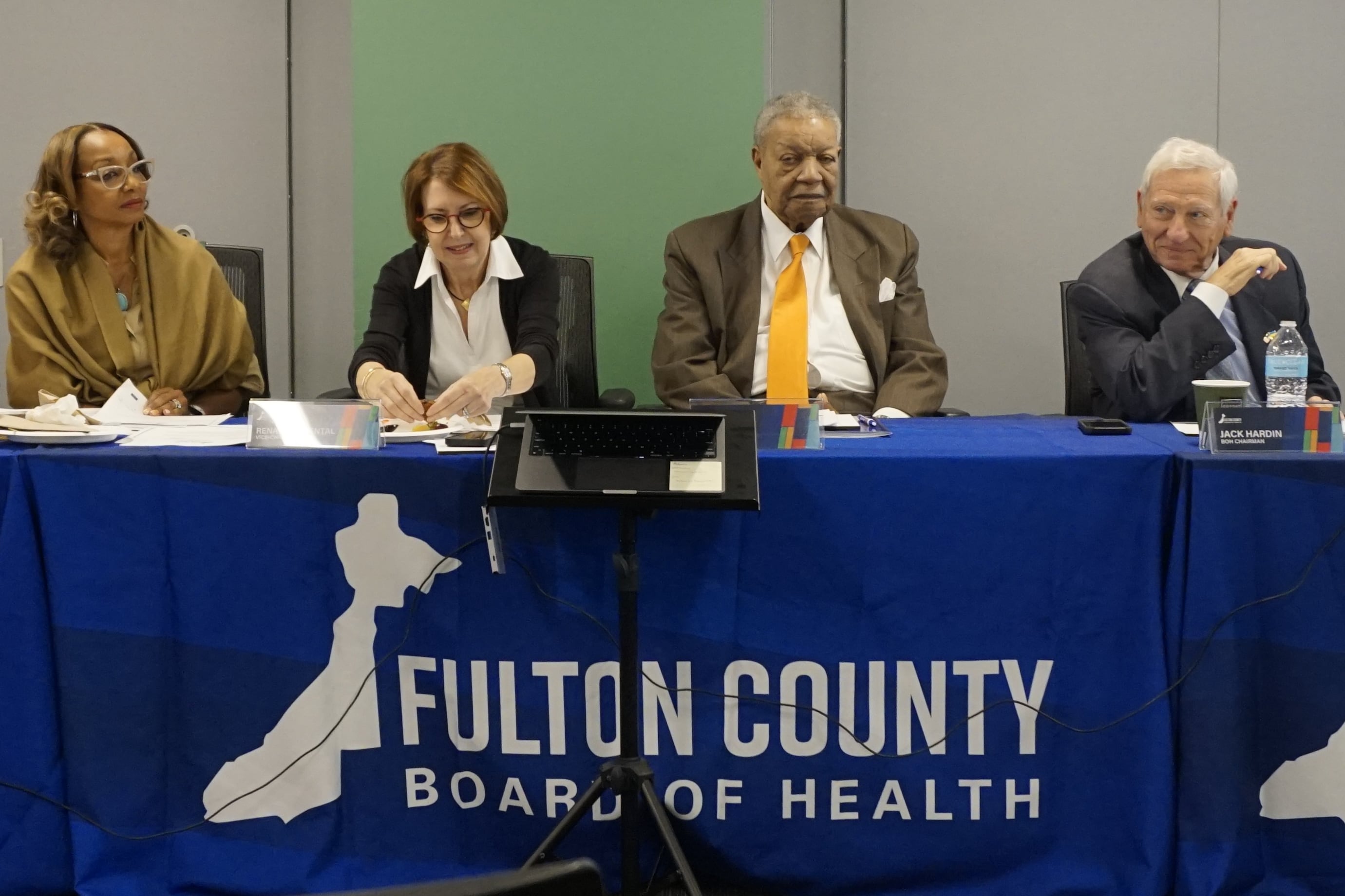 Four Fulton County Board of Health members sit behind a table.