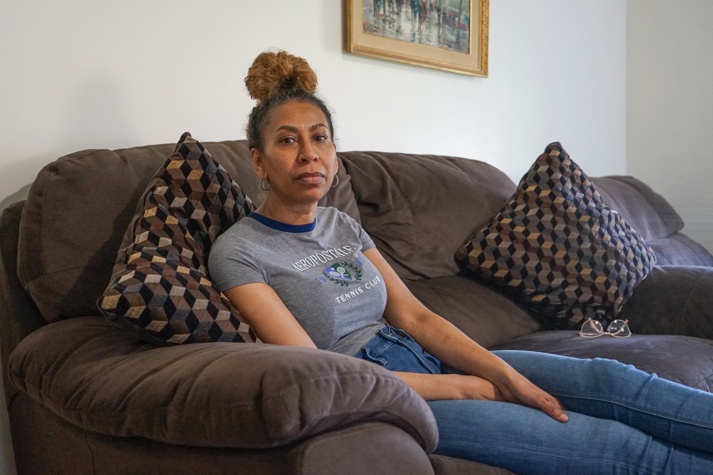 Debra Ragoonanan sits on a brown sofa.
