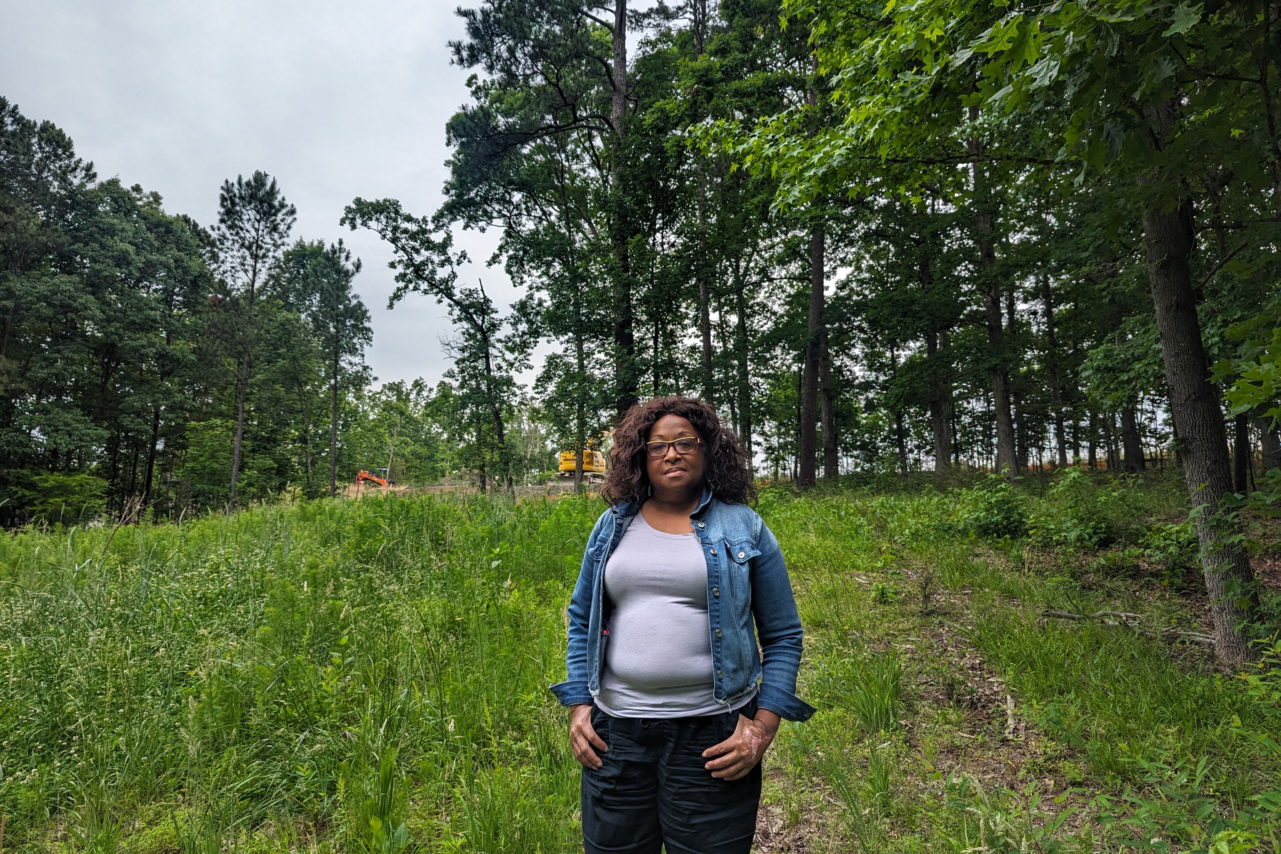 Bonita Green stands in a field with trees in the background.