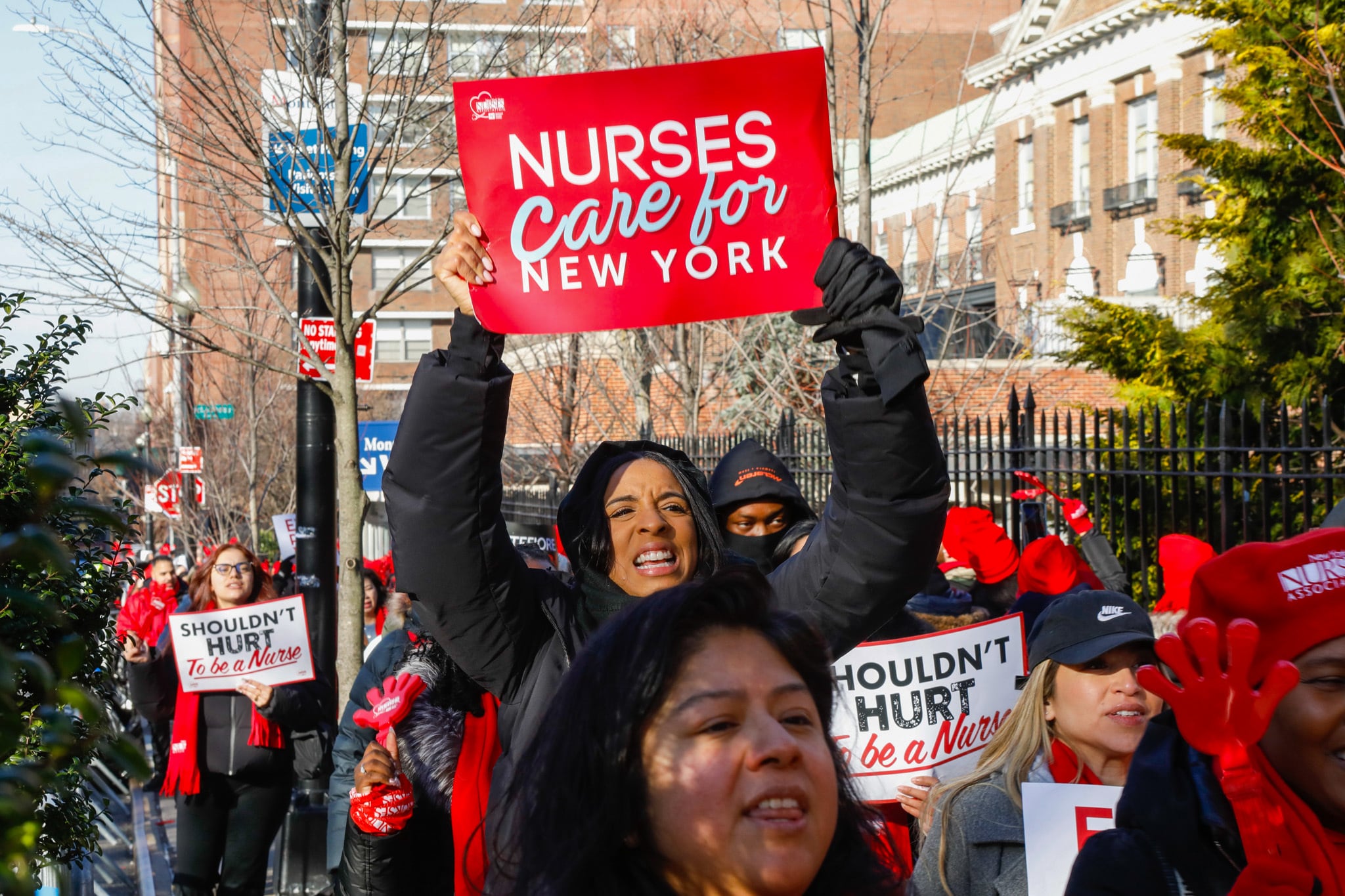 Nurses hold up signs while they picket on strike.