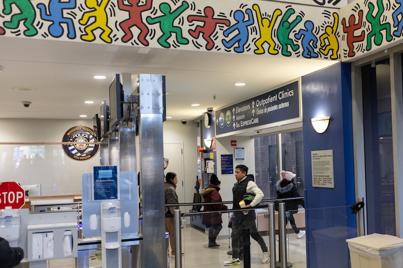 People walk in and out of a hospital.