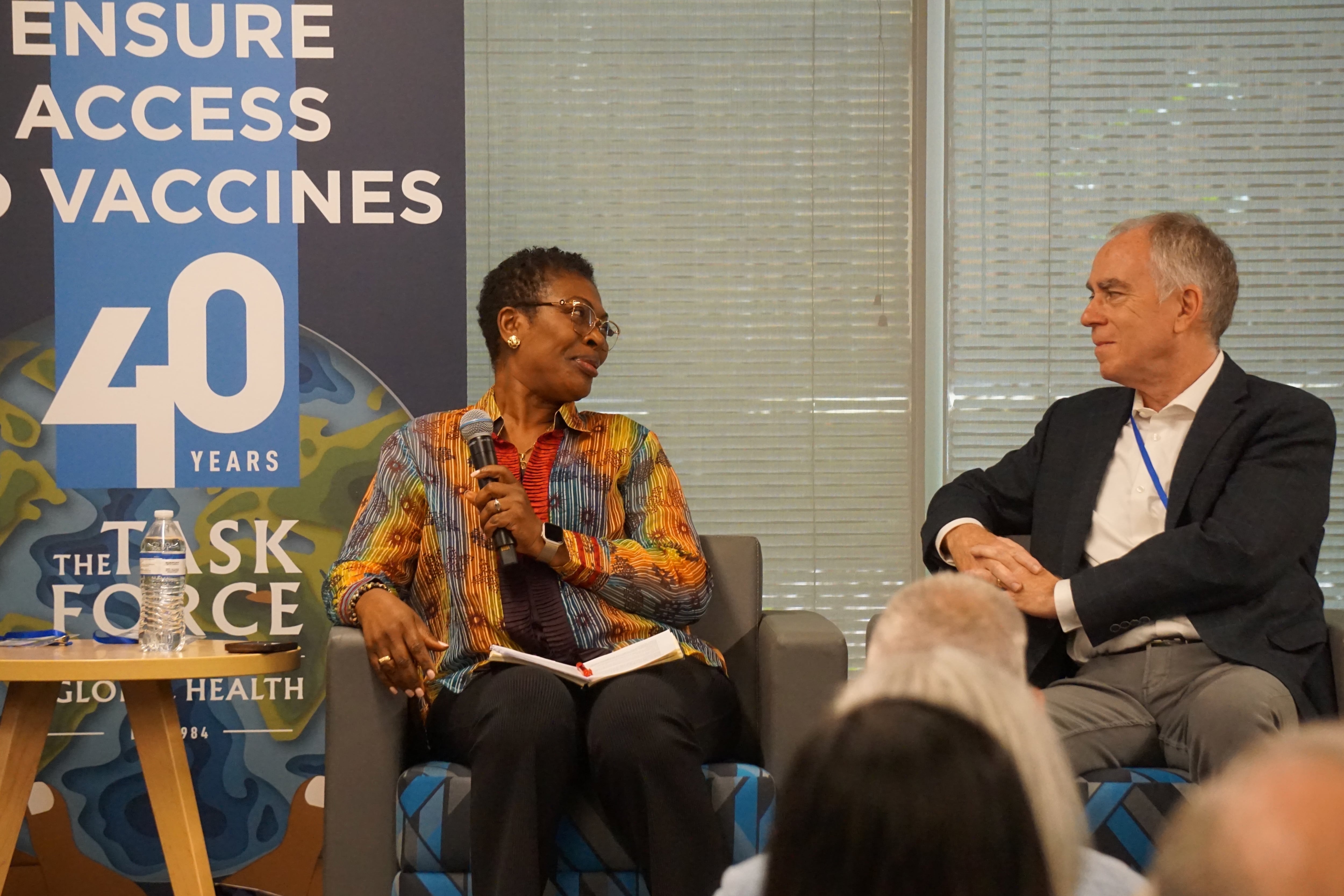 A woman and a man discuss global health during a panel in front of audience members at The Task Force for Global Health.