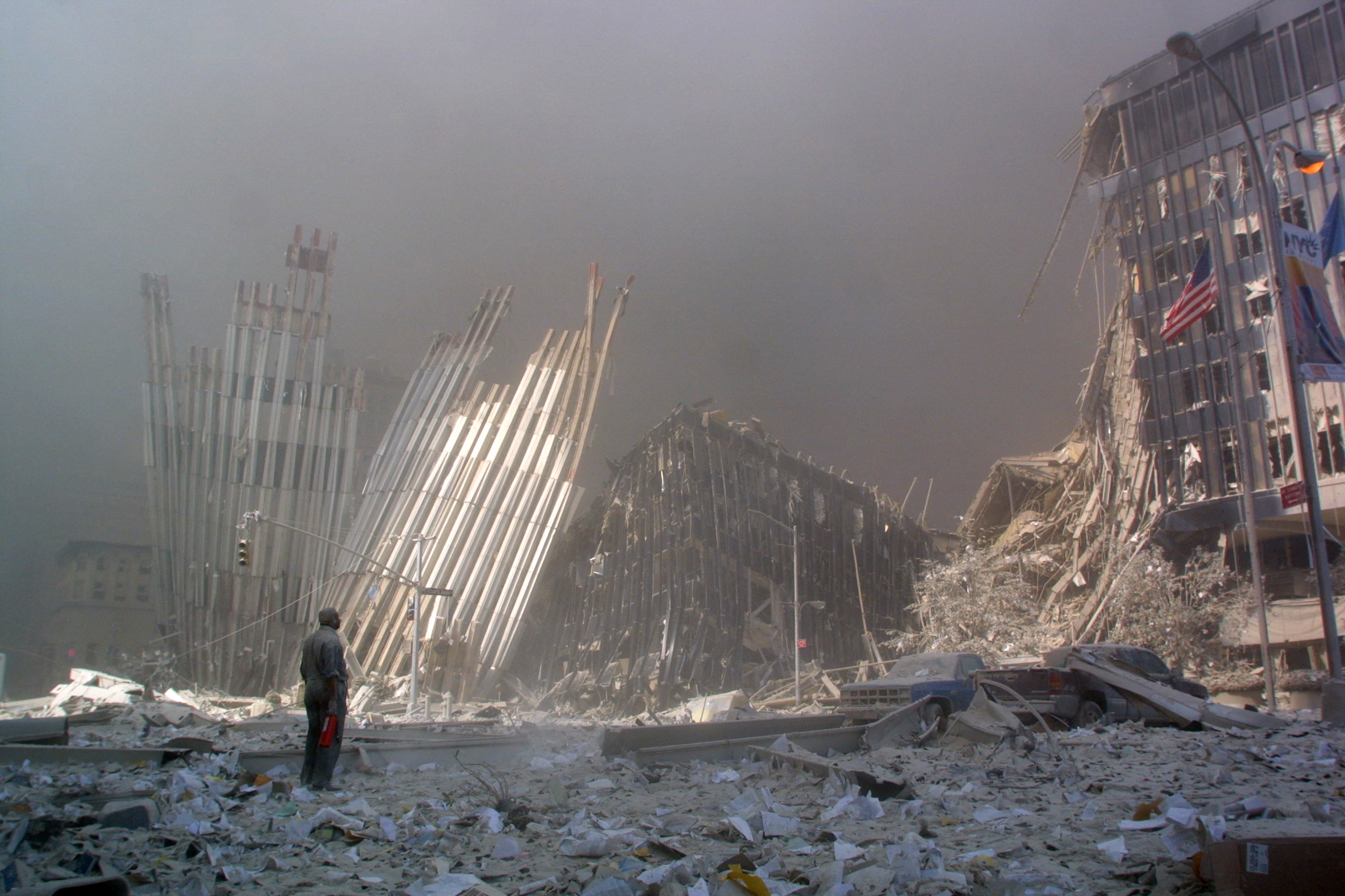 A man stands in debris surrounded by smoke from the collapse of the World Trade Center.