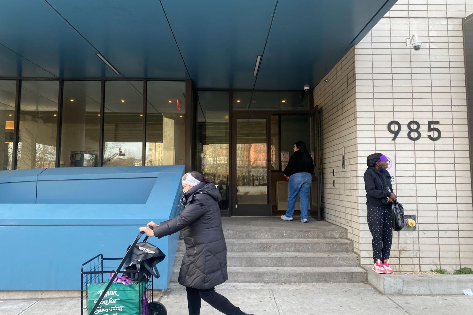 People stand outside a residential building.