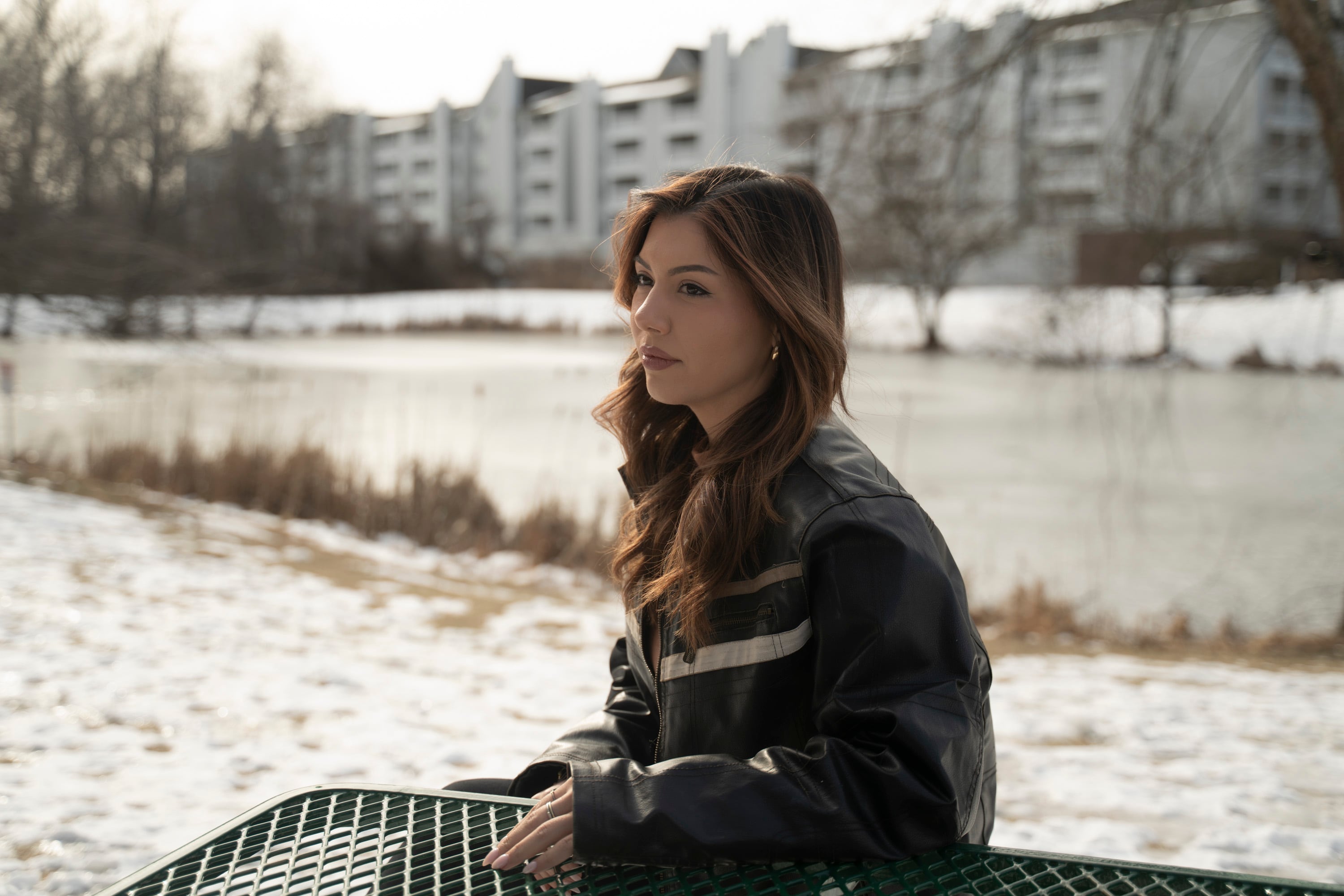 A woman stands outside an apartment building.