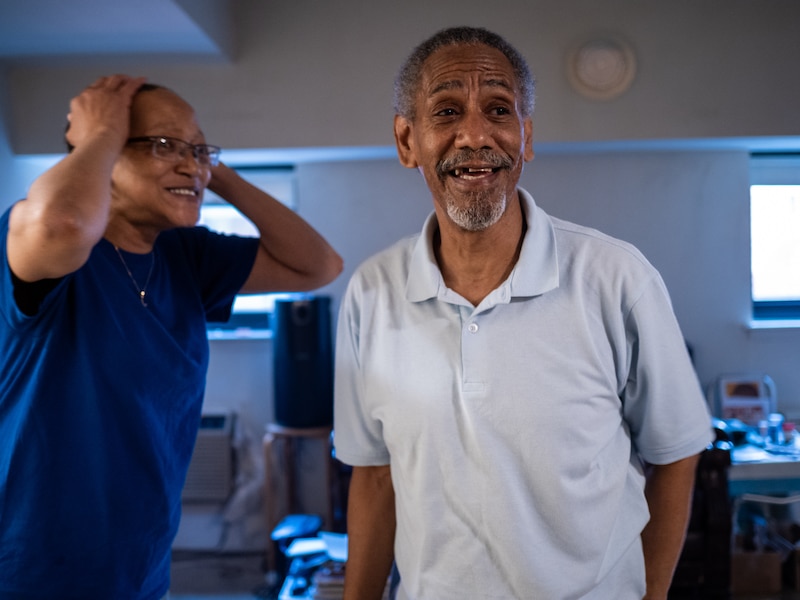 A woman in blue and a man in a white shirt interact.