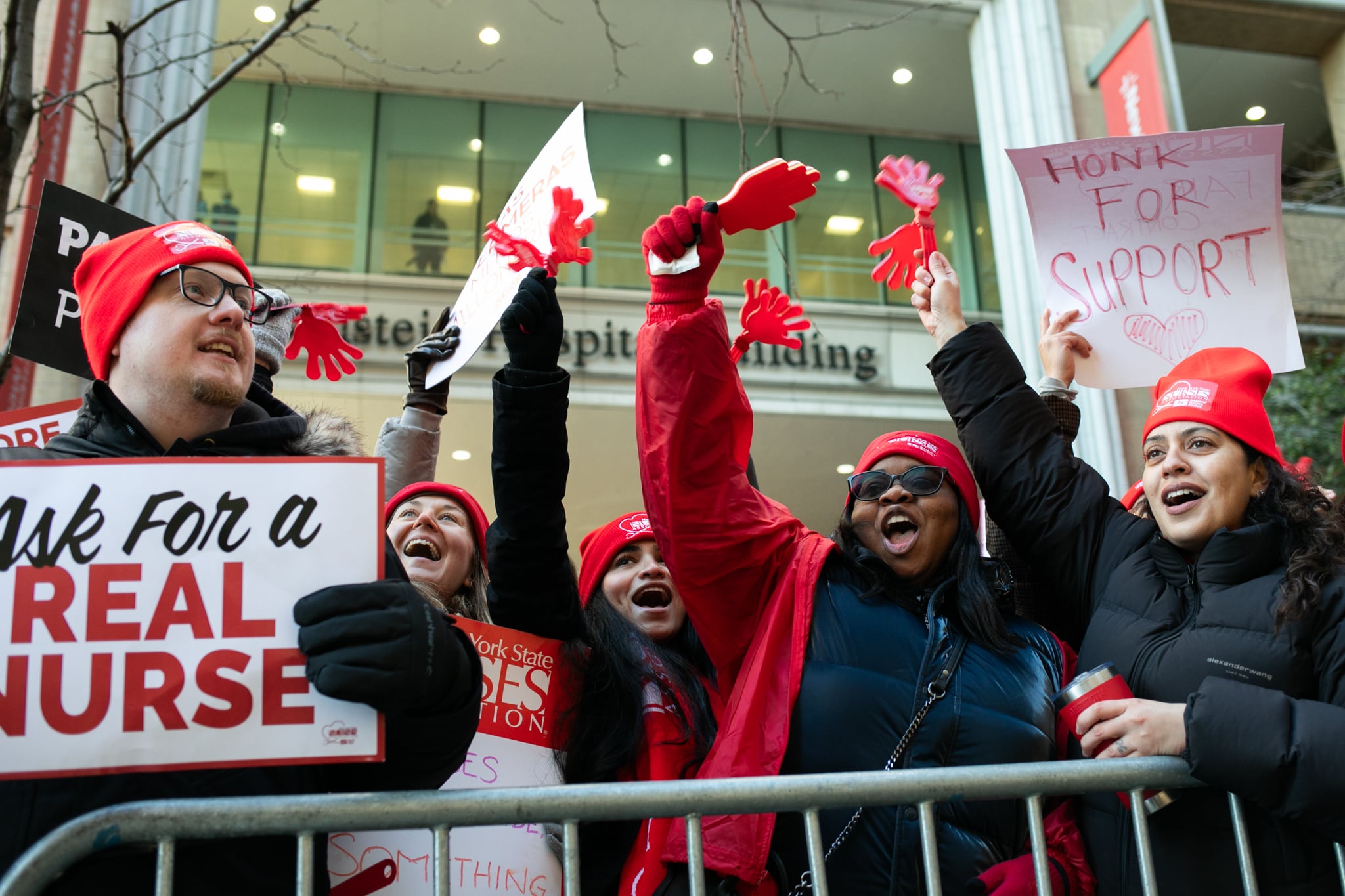 Striking nurses hold signs.