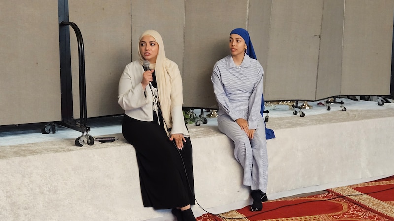 Jana Elsayed and Laila Salem speak to attendees of an event.