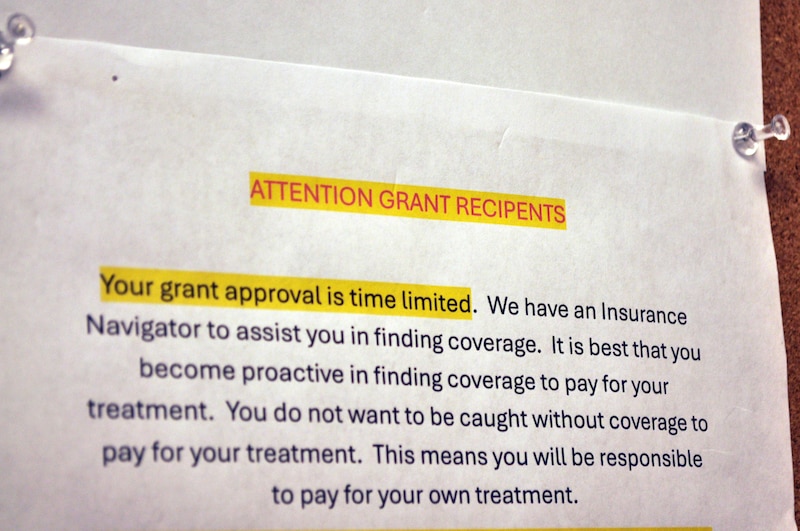 A white, yellow and red flyer on a wall.