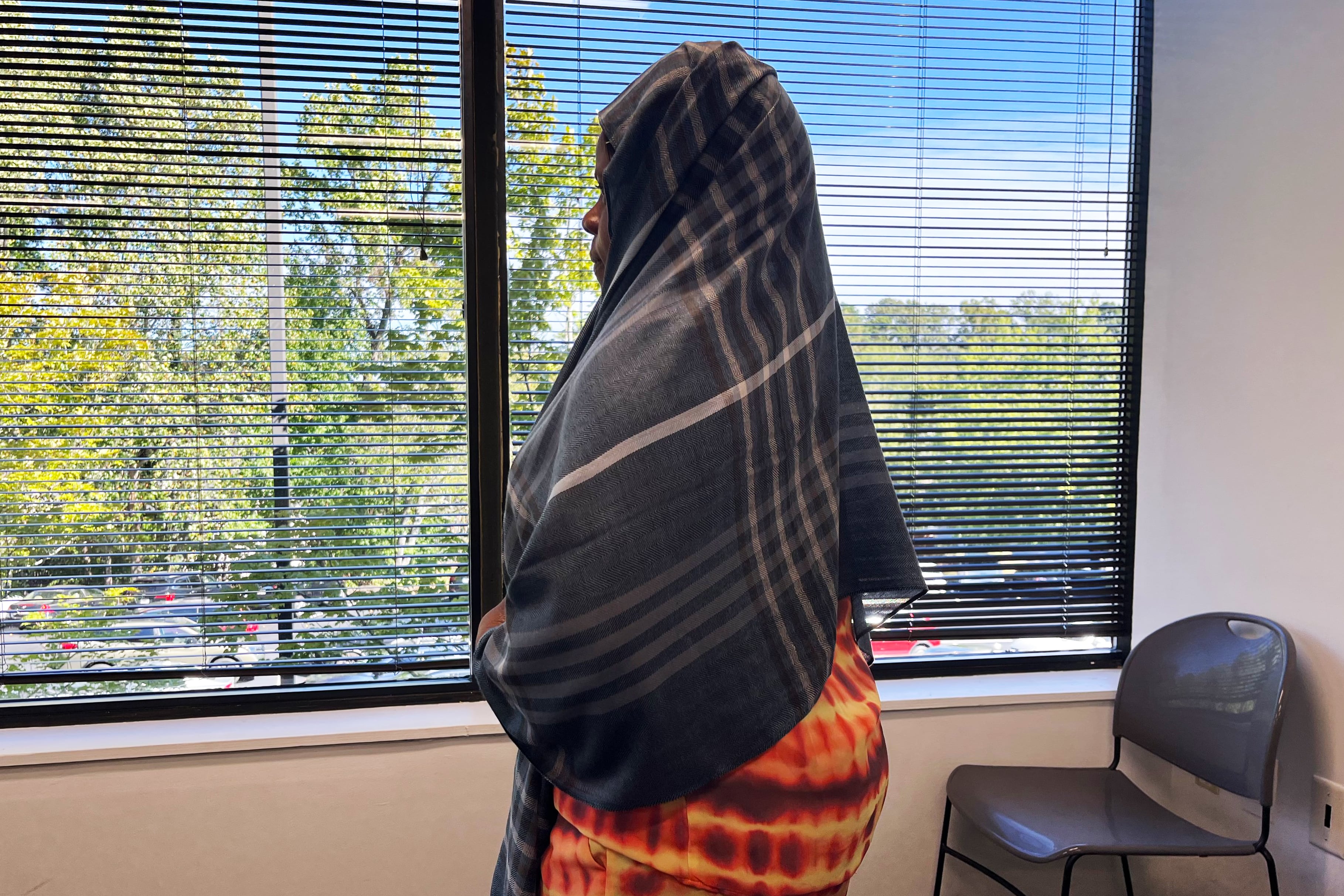 A woman stands at a window.