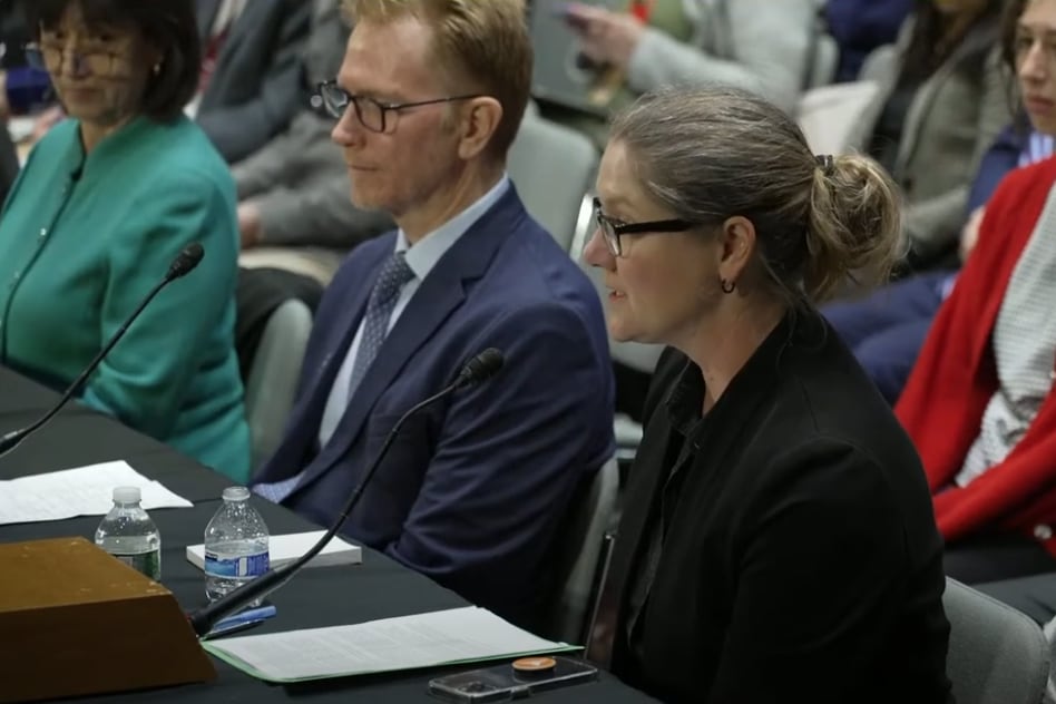 Three people are seated behind a table to speak at a forum by lawmakers about cuts to federal research funding.