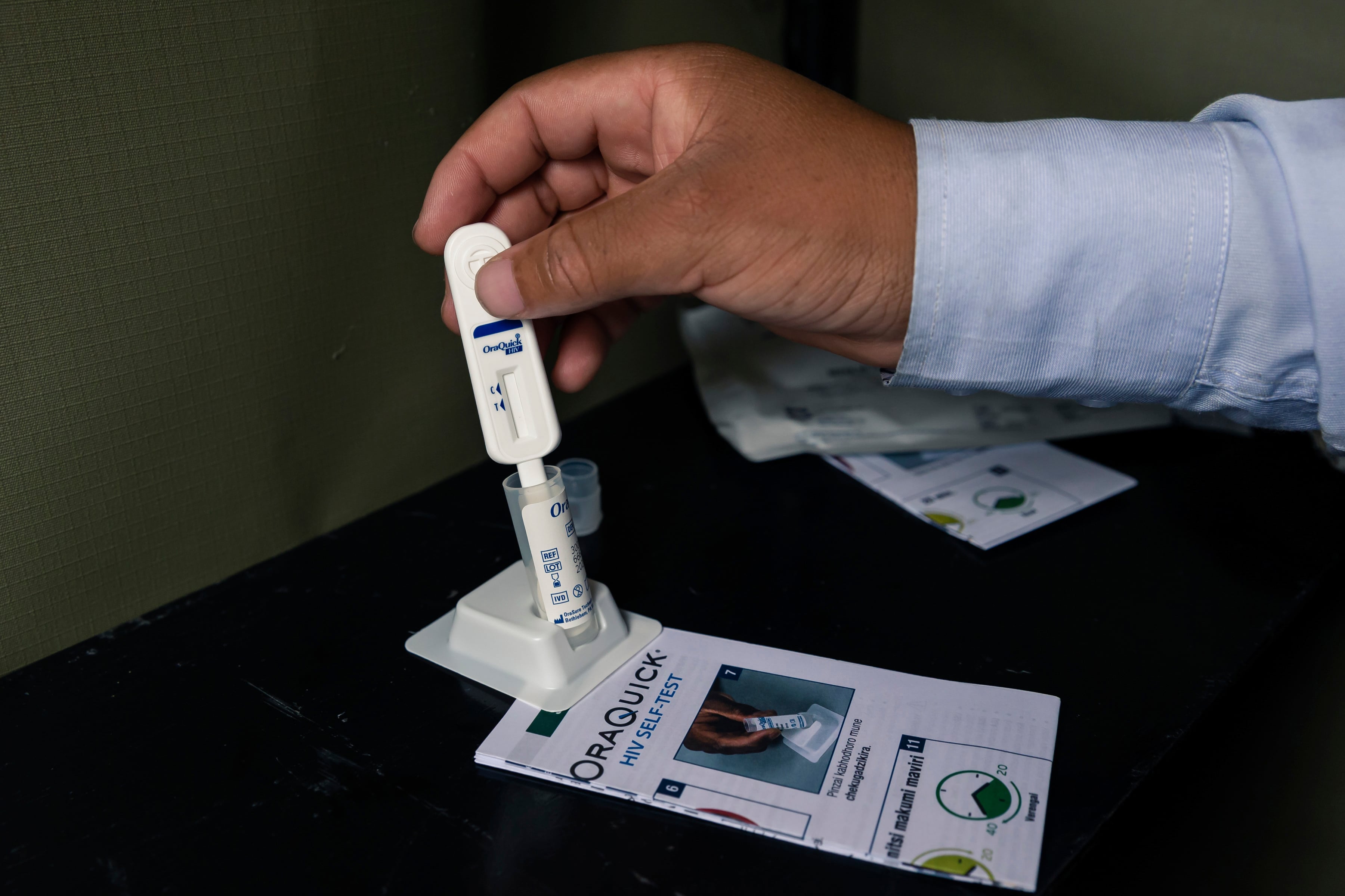 A hand holds an HIV self-test.
