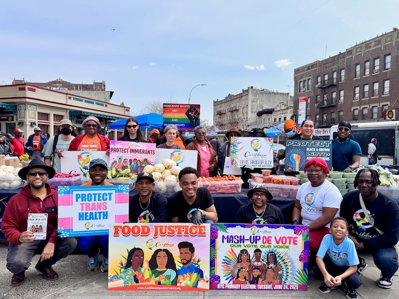 People holding colorful signs about food pose for a group photo.
