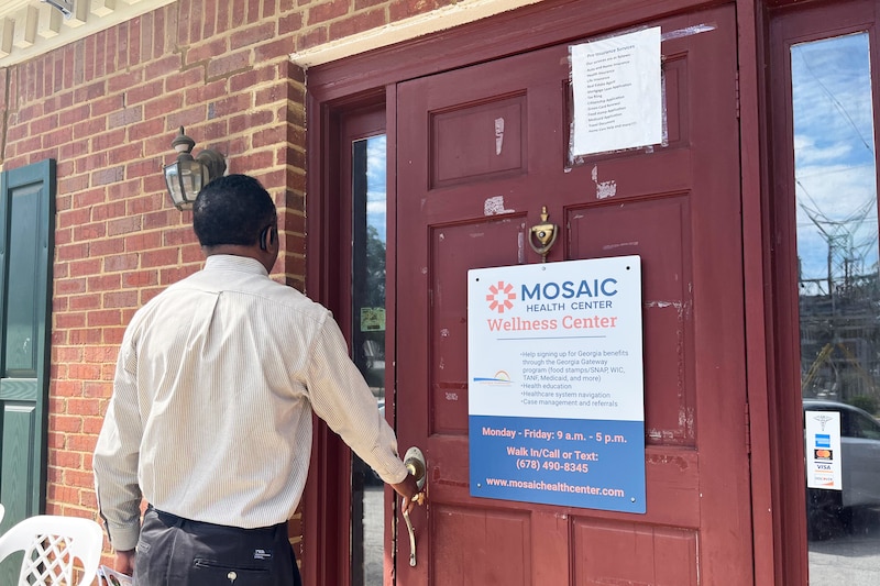 A man opens the door to a health clinic.