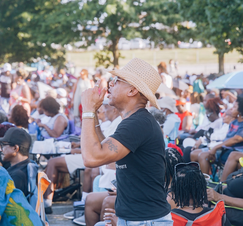 A man stands amid the audience at a music event in East Point, Georgia.