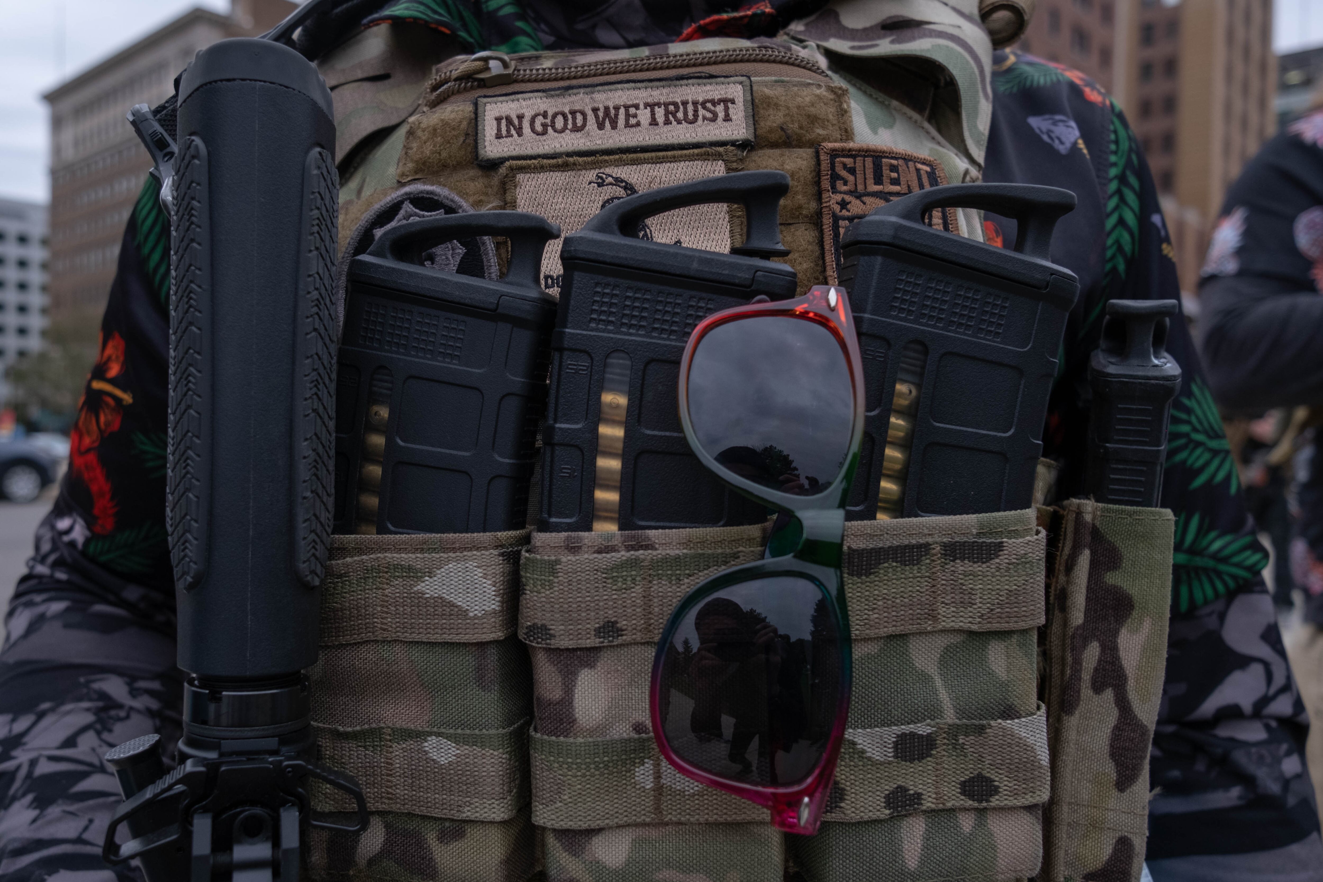 A closeup of a camouflage vest loaded with ammunition.