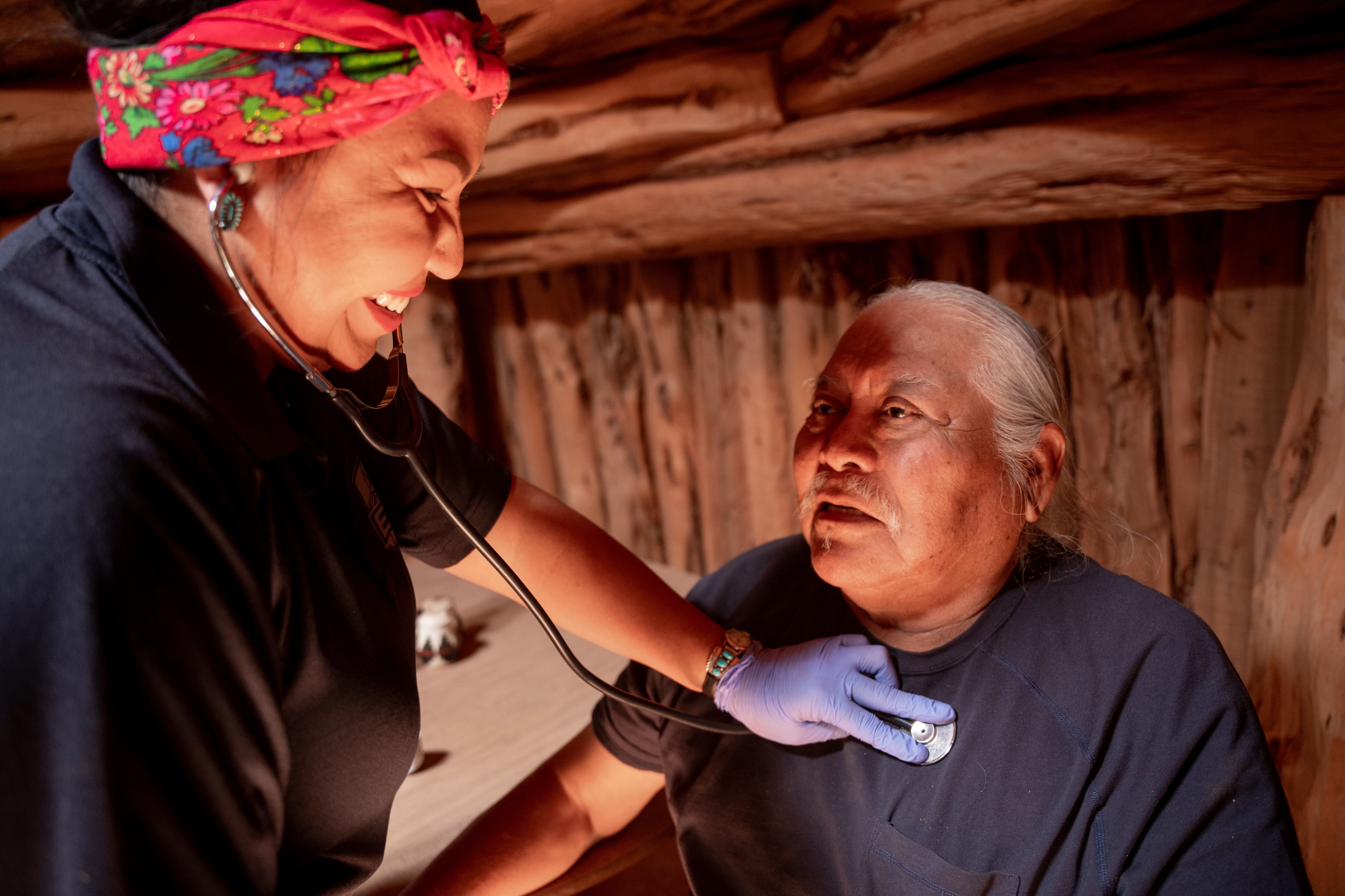 A paramedic examines a patient with a stethoscope.