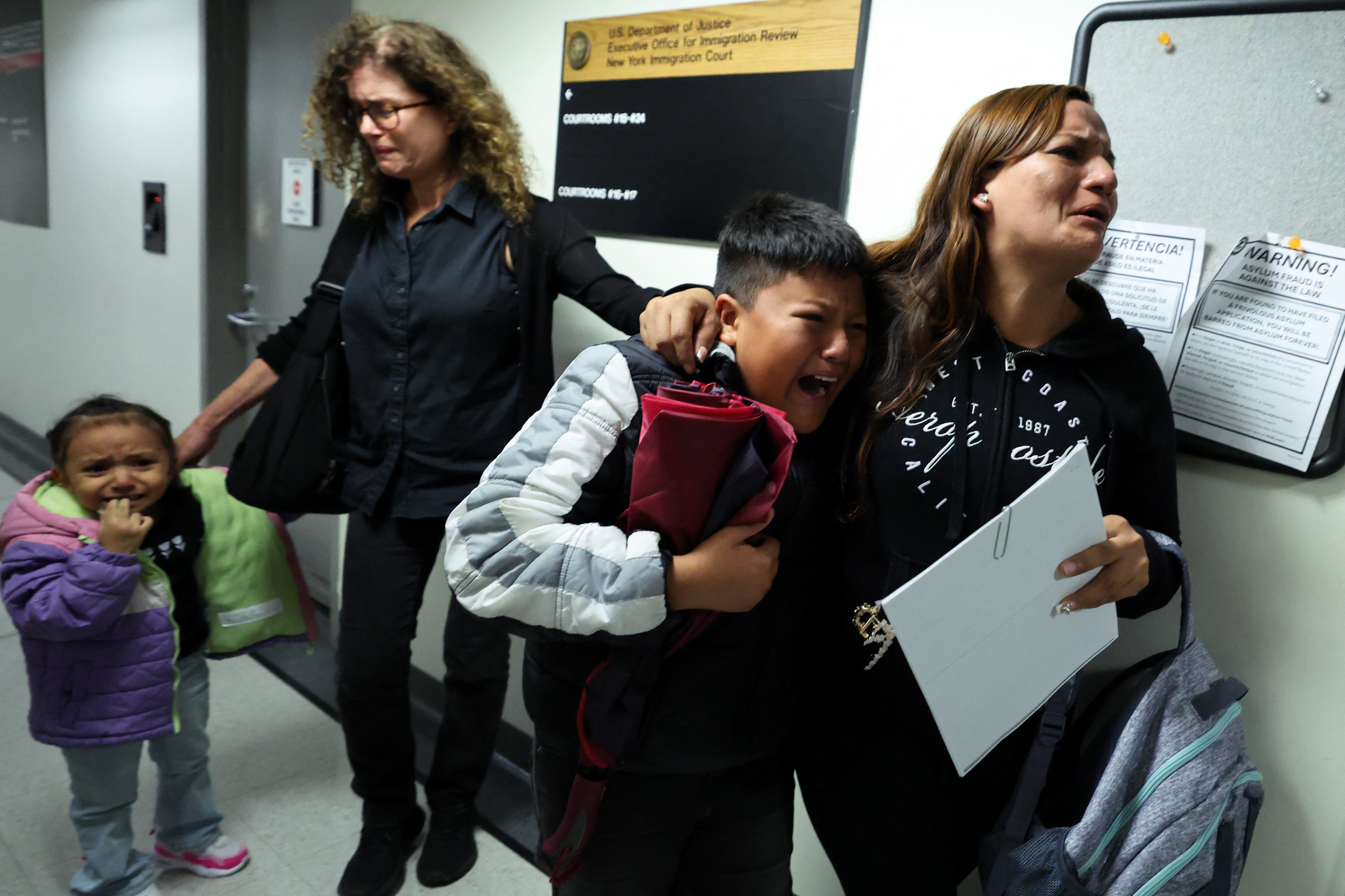 The distraught wife and crying children of a man detained by federal agents roam outside the courtroom where his hearing took place.